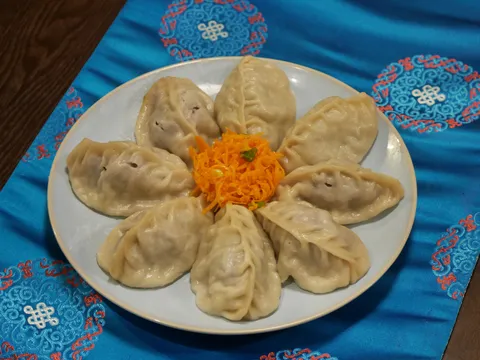 Buuz — steamed beef and lamb dumplings arranged around grated carrot