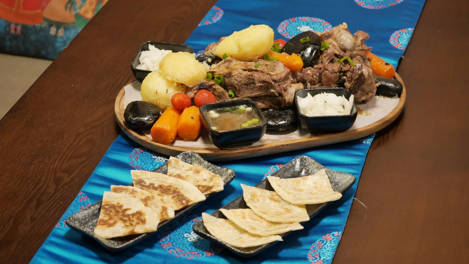 Large khorkhog board with hot stones, lamb and vegetables, flatbread and dipping sauces
